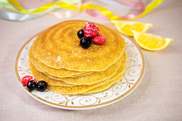 Russian pancakes decorated with berries on a white plate