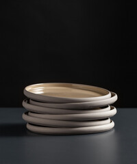 tableware, kitchen utensil and dishes concept - close up of ceramic plates on black table