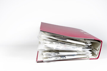 Red ring binder full of transparent punched pockets with receipts, office accounting concept, light...