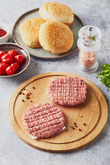 Raw veal mince Burger steak cutlets on wooden cutting board