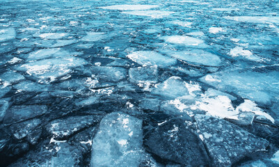 Blue uneven ice on the lake, abstract natural background.