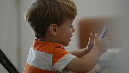 Candid boy using phone child holding smartphone using tech
