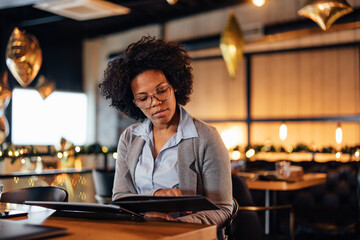 Thoughtful African-American woman, coming to her favorite restaurant.