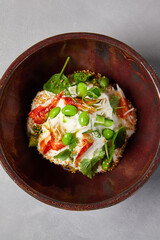 Chef salad with crab, quinoa, vegetables and edamame beans on dark homemade ceramic bowl. Salad bowl with crab, avocado, cream sauce in modern serveware. Modern dishware on concrete background.