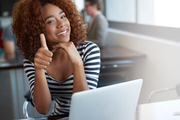 Youve got her seal of approval. Portrait of a young woman winking and giving the thumbs up while...