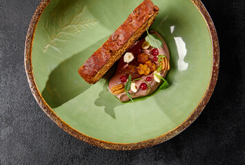Chicken liver pate with artisan bread in green handmade ceramic plate. Appetizer from liver with...