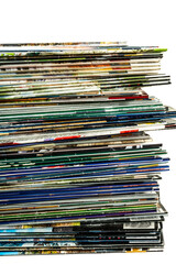 A messy pile of old, colorful magazines on light background.