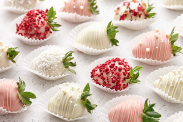 White and pink chocolate dipped strawberries on white table
