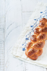 Challah bread. Sabbath kiddush ceremony composition. Freshly baked homemade braided challah bread for Shabbat and Holidays on white wooden background, Shabbat Shalom. Top view. Copy space. - obrazy, fototapety, plakaty