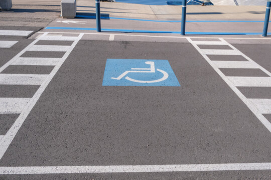 Empty convenient parking for cars with places for disabled people. Free Disabled parking with pedestrian crossing. Marking on asphalt road.