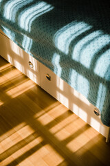 Bedroom in the morning. Shadows from the windows on the bed on sunny day. 
