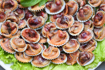 Peeled cockles with seafood sauce and vegetable salad lettuce on plate  wooden background, Fresh raw shellfish blood cockle ocean gourmet seafood in the restaurant, sea shells food