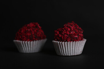 two chocolate candies isolated against dark background