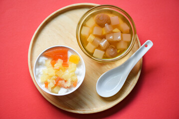 Chinese desserts, milk pudding fruit salad and Mix ginkgo nuts cassava syrup coconut jelly in longan juice on glass bowl, Thai and Chinese longan date soup Asian dessert sweets