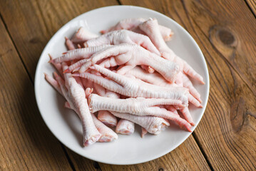 Fresh raw chicken feet for cooked food on the wooden table kitchen background, chicken feet on...