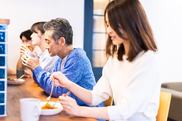 Obraz na płótnie Canvas レストランのカウンター席でご飯を食べる人々