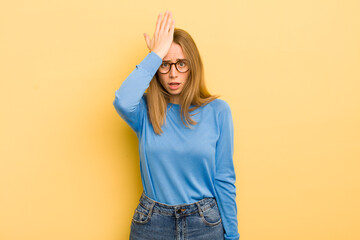 pretty caucasian woman raising palm to forehead thinking oops, after making a stupid mistake or remembering, feeling dumb - obrazy, fototapety, plakaty