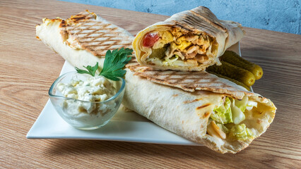 Shawarma chicken roll. Fresh roll of thin lavash or pita bread filled with grilled meat, cheese, carrots, sauce, green.