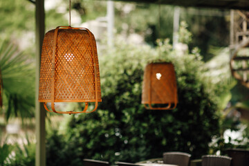 Wicker lampshade in an outdoor street cafe. Vintage decorative