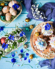 Easter cupcakes. Painted eggs. Grass and flowers in a shell. Easter still life. Easter background