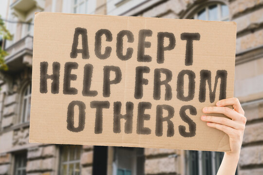 The phrase " Accept help from others " on a banner in men's hand with blurred background. Admit. Share. Deal. Rescue. Agree. Deed. Focus. Trust. Team. Reach. Need. Effort. Action. Hand. Help. Raise - Powered by Adobe