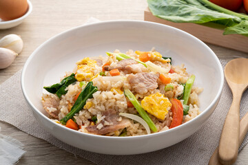 Easy Pork Fried Rice with kale, carrot, egg, onion and tomato in white plate