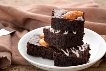 Close up Chocolate Brownie topping with cashew nut on white plate.Delicious taste bitter sweet, chewy and fudge