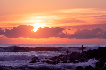 Sunrise surfers on the rocks at Burleigh Heads, Gold Coast