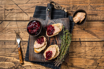 French cuisine Foie gras toasts, goose liver pate and lingonberry marmalade. wooden background. Top view - obrazy, fototapety, plakaty