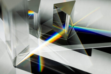 Multi triangular Prism dispersing sun beam splitting into a spectrum on white background - obrazy, fototapety, plakaty