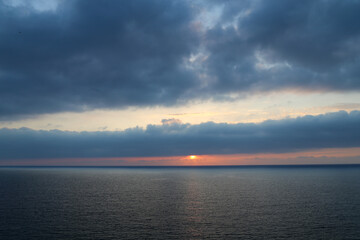 Sunset over the Mediterranean sea with clear sky. Sun over the water with cloudy atmospheric moods