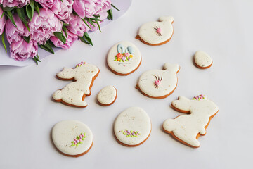 Easter composition with sweet bread, gingerbread rabbits and eggs, bouquet of flowers tulip. Holidays breakfast. Traditional easter gingerbread cookies. Easter Greeting Card Template