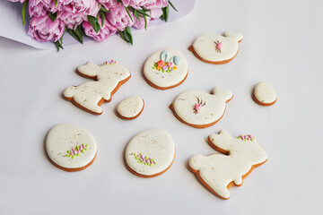 Easter composition with sweet bread, gingerbread rabbits and eggs, bouquet of flowers tulip....