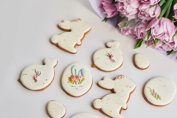 Easter composition with sweet bread, gingerbread rabbits and eggs, bouquet of flowers tulip. Holidays breakfast. Traditional easter gingerbread cookies. Easter Greeting Card Template