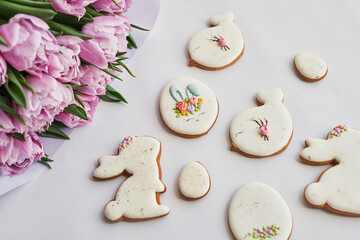 Easter composition with sweet bread, gingerbread rabbits and eggs, bouquet of flowers tulip. Holidays breakfast. Traditional easter gingerbread cookies. Easter Greeting Card Template