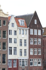 Fototapeta na wymiar Amsterdam Damrak Canal Traditional House Facades with Spout and Pointed Gables, Netherlands