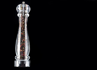 Obraz na płótnie Canvas mixed peppercorns black white and red colour decoration with a pepper grinder, top view on black background , copy space