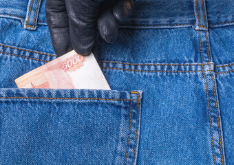 From the back pocket of jeans, the thief pulls out a Russian banknote of 5000 rubles