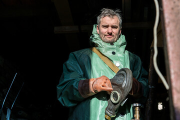 Portrait of middle aged male worker wearing gas mask for radioactive accident liquidation