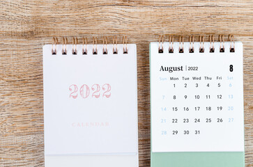 August 2022 desk calendar on wooden background.