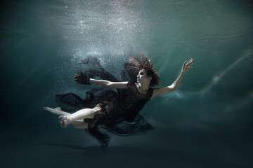a girl in a black dress in the water