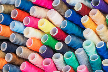 Mixture of colourful spools of thread. Multicolor sewing threads background. Yarn on a spool,...