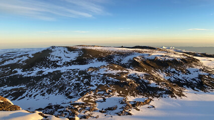View from the top of Kilimanjaro to the snow-covered crater of the volcano. Beautiful sunrise in the mountains.