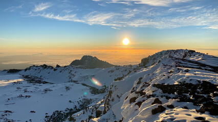 Amazing panorama from Uhuru Peak. Dawn in the mountains. Snow-covered crater of Mount Kilimanjaro.