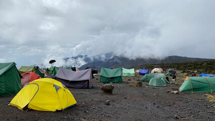 Multi-colored tents stand in the mountains. Beautiful mountain landscape. Climbing Kilimanjaro,...