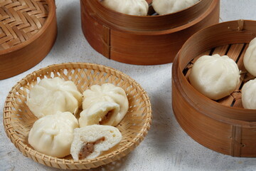 bao zi or bapao,bakpao-Chinese steamed buns,served in bamboo steamer.white background 