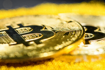 Close up golden bitcoins on yellow gold placer surface, selective focus. Crypto currency. Bitcoin...