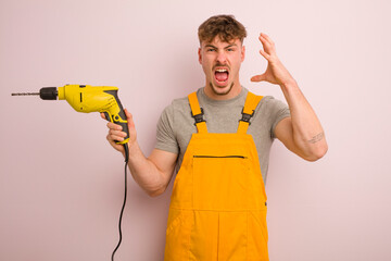 young cool man screaming with hands up in the air. handyman and drill concept