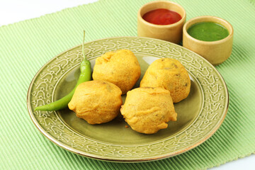 Indian snack aloo vada or bonda made from potato with coconut chutney. Indian snacks Aloo Bonda vada, pakoda, pakora.Paneer bonda indian snack, Served with tomato sauce placed 