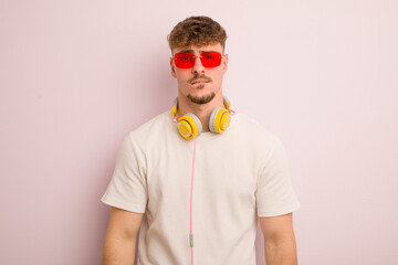 young cool man looking puzzled and confused. sunglasses and headphones
